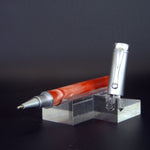 Pen with red and silver design on a clear stand against a dark background