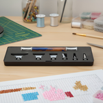 Cross-stitching tools and materials on a wooden table