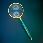 Magnifying glass with a green handle on a blue background