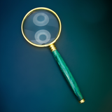 Magnifying glass with a green handle on a blue background